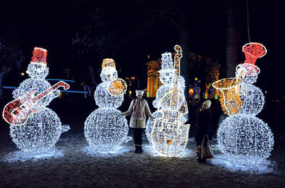 A set of four Giant LED Snowmen decorated with bright lights, displayed outdoors at night.
